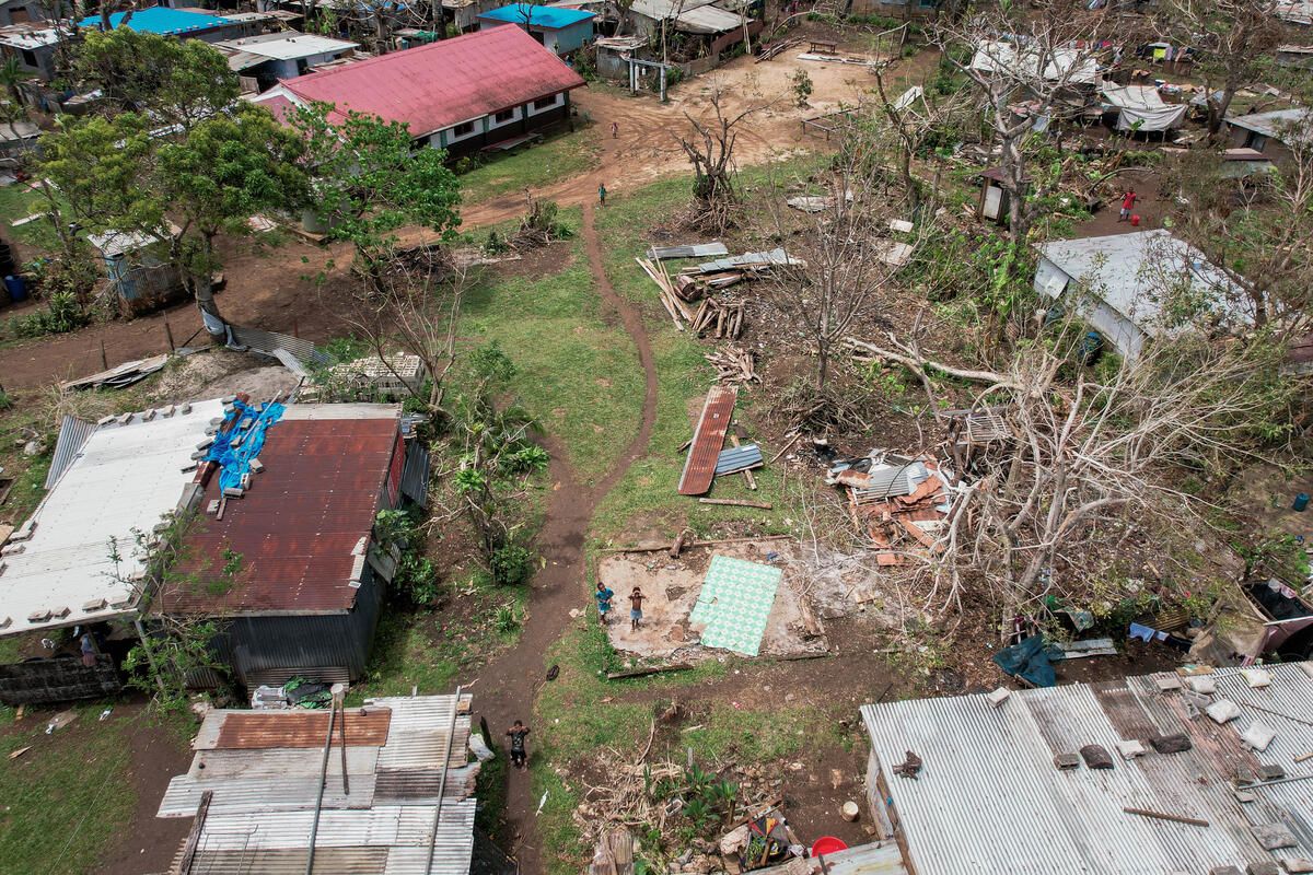 Rachel, a 15-year-old climate campaigner, in front of her family's house that was badly damaged during the tropical cyclones - Judy and Kevin in Vanuatu.